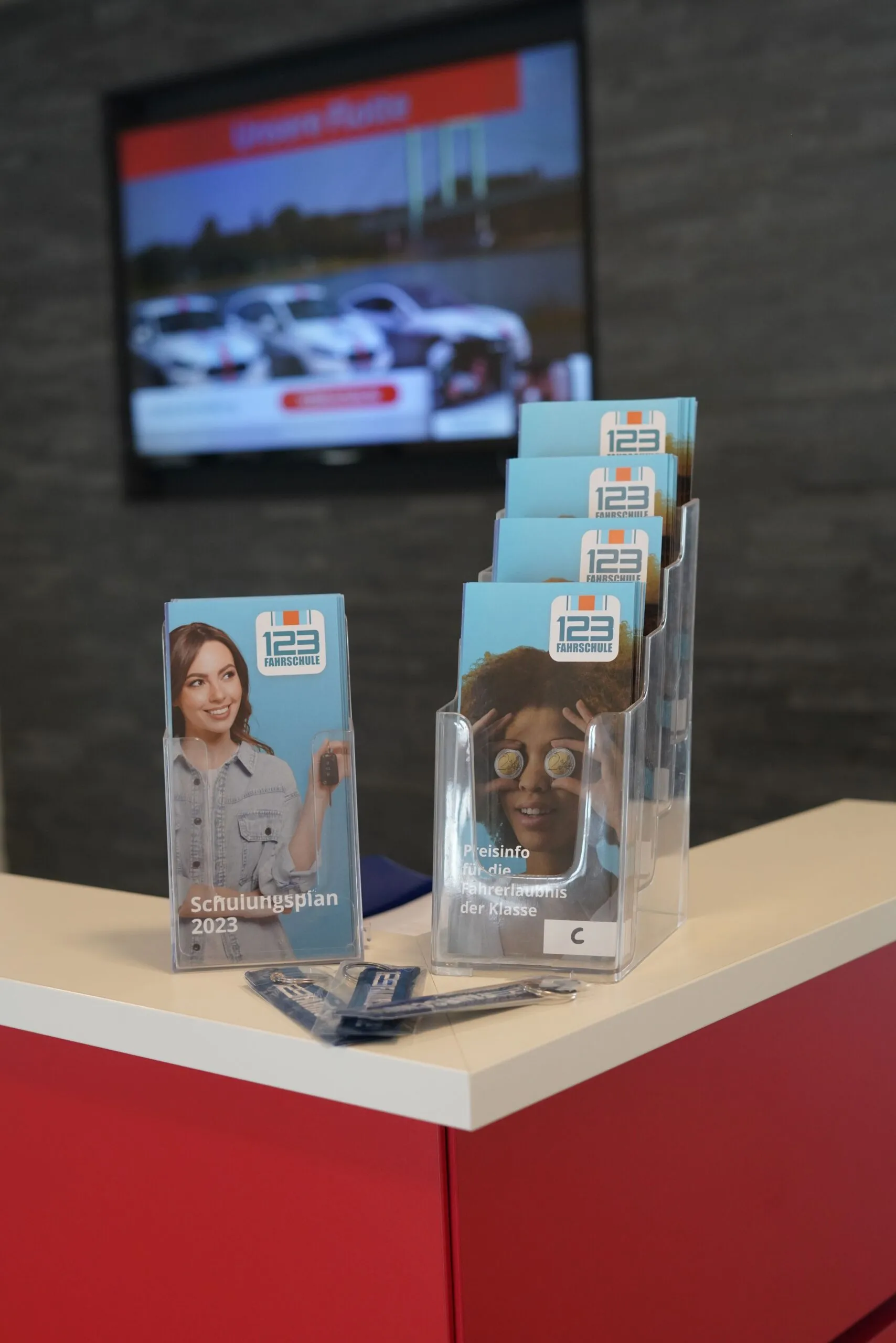 Rezeption der 123 Fahrschule. Auf dem Desk der Rezeption stehen Werbe-Flyer für die Führerscheinausbildung